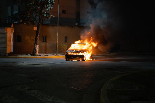A car on fire in the street 