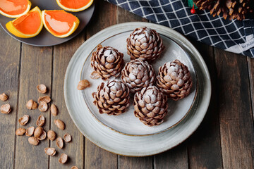 Christmas tree cone, shaped cakes with chocolate flakes with powdered sugar. The concept of trendy dessert for New Year or Christmas. Side view, low key.