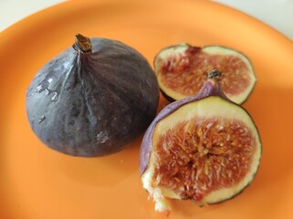 Purple figs in orange plate