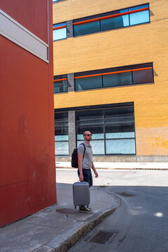 Quebec City, man standing on sideroad with suitcase