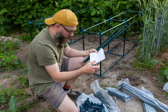 a man reads the instructions for assembling a greenhouse