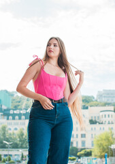 Youth concept. Nice beautiful Slavic beauty with long blonde hair, girl in pink top and jeans...