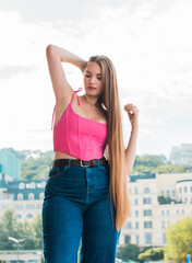 Youth concept. Nice beautiful Slavic beauty with long blonde hair, girl in pink top and jeans...