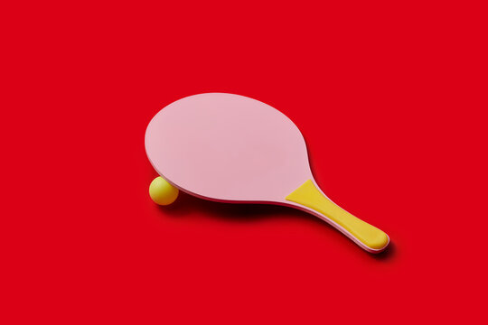 Pink racket with yellow handle covering little balloon