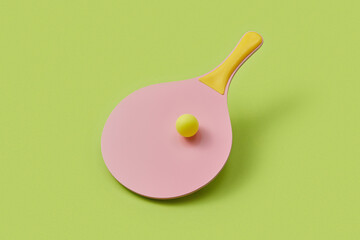 Plastic racket with yellow handle and ball rolling on surface