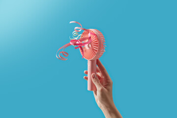 Palm of human holding portable ventilator with attached laces