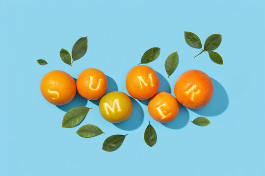 Stack of oranges with inscription of summer on peel in studio