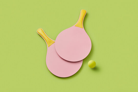 Crossed paddles for pickleball laying on green background