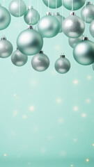 Hanging silver christmas ornaments on light teal background