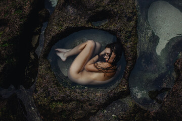 Photo of naked girl in the water in the fetal position
