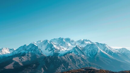 Majestic mountain range with snow-capped peaks under a clear blue sky