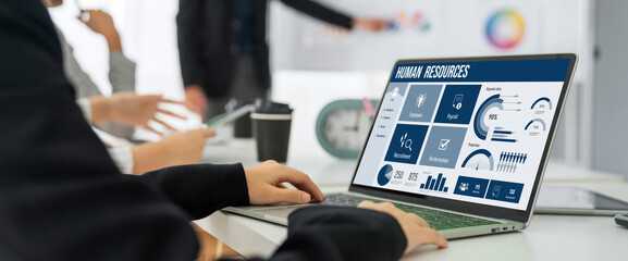 Human resources management software on computer screen helping human resources employee to manage...