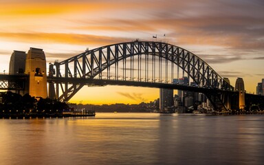 Fototapeta premium Harbour Bridge Sunset Silhouette: Dramatic Sydney Skyline Background