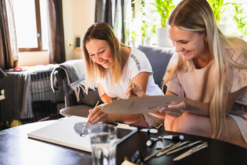 Woman with a Disability and Assistant Painting Together at home