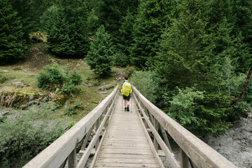 teen boy on bridge, hiking the Tour du Mont Blanc, in the Swiss Alps, 
