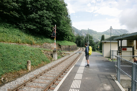 teen boy waiting  for train during a backpacking trip