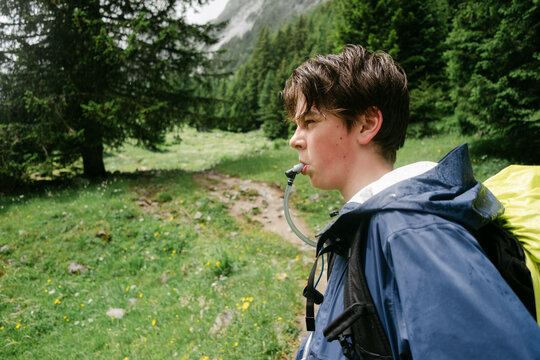 teen hydrating while on  the Tour du Mont Blanc, in the Swiss Alps, 