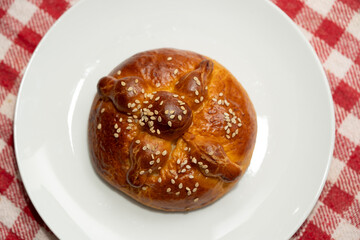 pan de muertos de yema de huevo sobre plato blanco, centrado