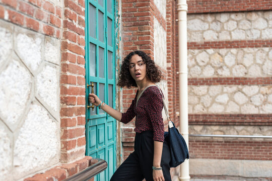 Curly-haired student entering campus building