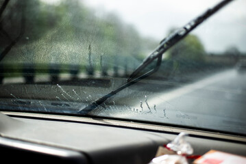 Windshield wipers clearing rain on a road