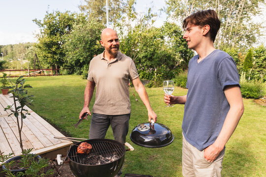 Father and Son Enjoy a Sunny Backyard Barbecue