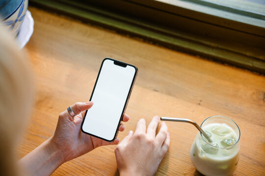 A woman uses a mobile phone with white screen