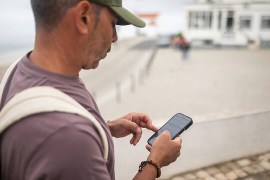 man walking down the street using his mobile phone
