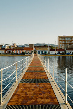 A pier extending towards a coastal town on the Mar Menor in Murcia