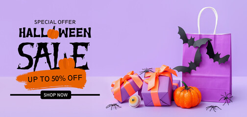 Composition with shopping bag, gift boxes, bats and pumpkin for Halloween on purple background