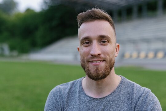 Close-up portrait of sportsman standing on football field 