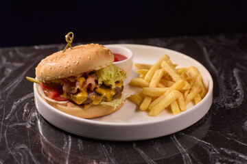 A Delicious Burger served with Crispy Fries and a side of Ketchup on a Dark Marble Table