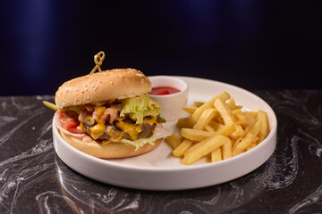 A Delicious Burger served with Crispy Fries and a side of Ketchup on a Dark Marble Table