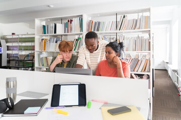Group of students collaborating in library on project work.
