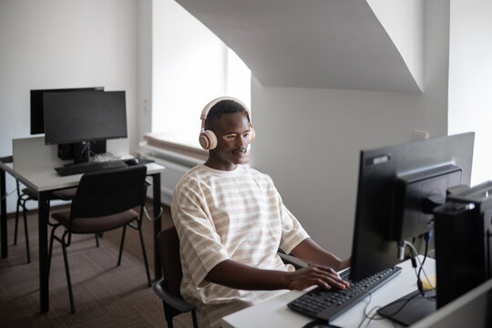 Student wearing headphones using computer
