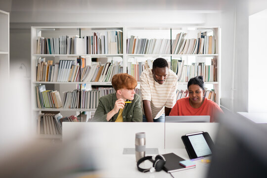 Three students studying together in library