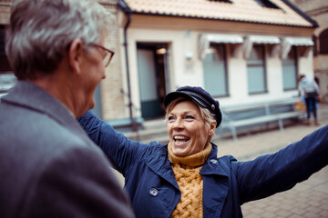 Senior couple laughing and exploring city with a map