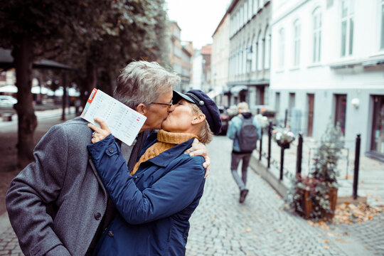 Senior couple laughing and exploring city with a map