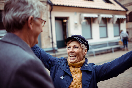 Senior couple laughing and exploring city with a map