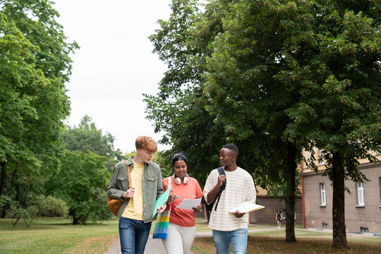 Three students walking outside dorm