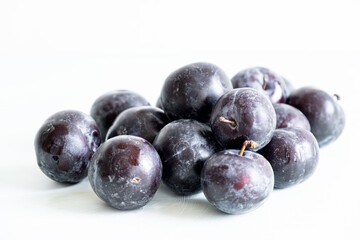 Ripe plums on a white background