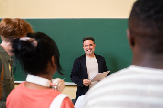 Smiling teacher talking to his students