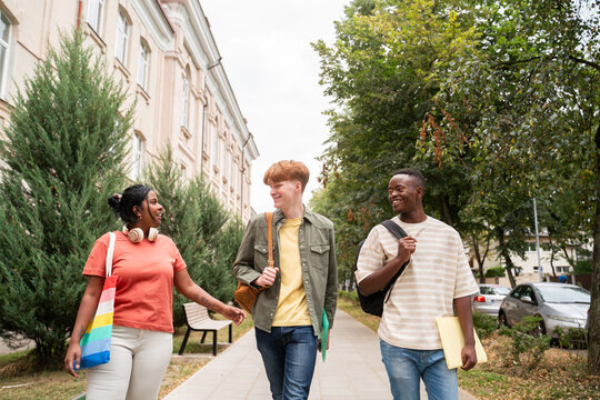 Happy students walking outside university