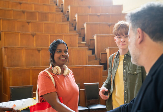 Student handshake with teacher in lecture hall 