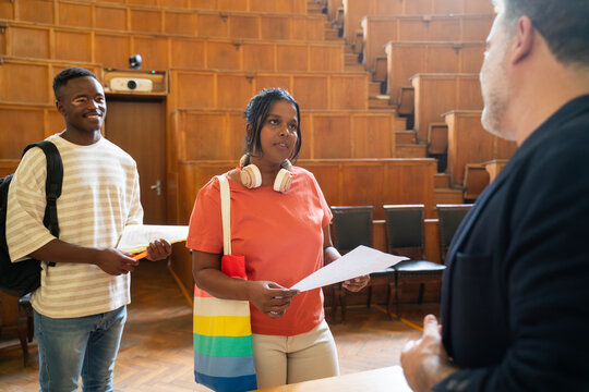 Students and professor at university auditorium after exam