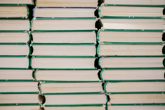 Stacks of old books aligned neatly on a shelf.