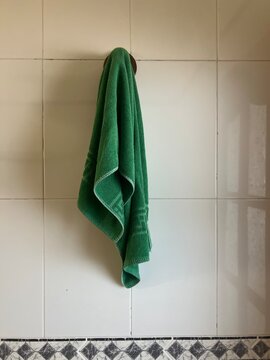 Green Towel Hanging on Bathroom Wall