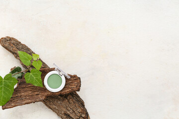 Green eye shadow with leaves and tree bark on grunge white background
