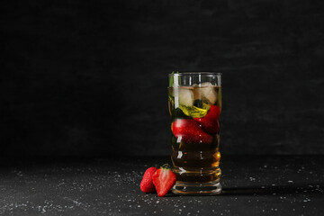 Glass of ice tea with strawberry and mint on black background