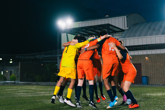 Football team excited under the stadium lights.