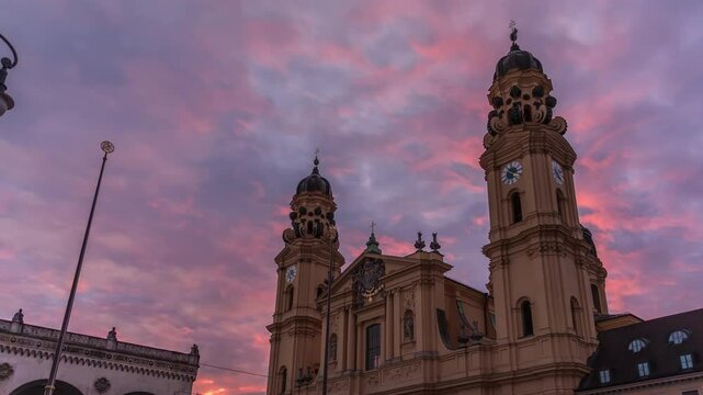 The Theatine Church of St. Cajetan (Theatinerkirche St. Kajetan) timelapse during sunset. A domed baroque Catholic church with striking yellow facade and ornate white stucco interior. Munich, Germany